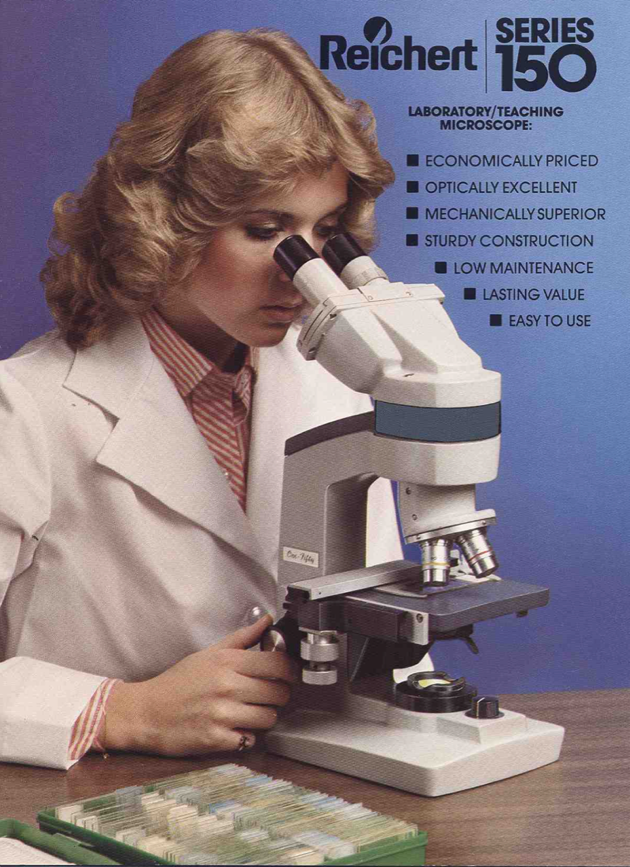 A person looking through a microscope
Description automatically generated