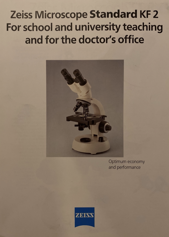 A white and black microscope
Description automatically generated