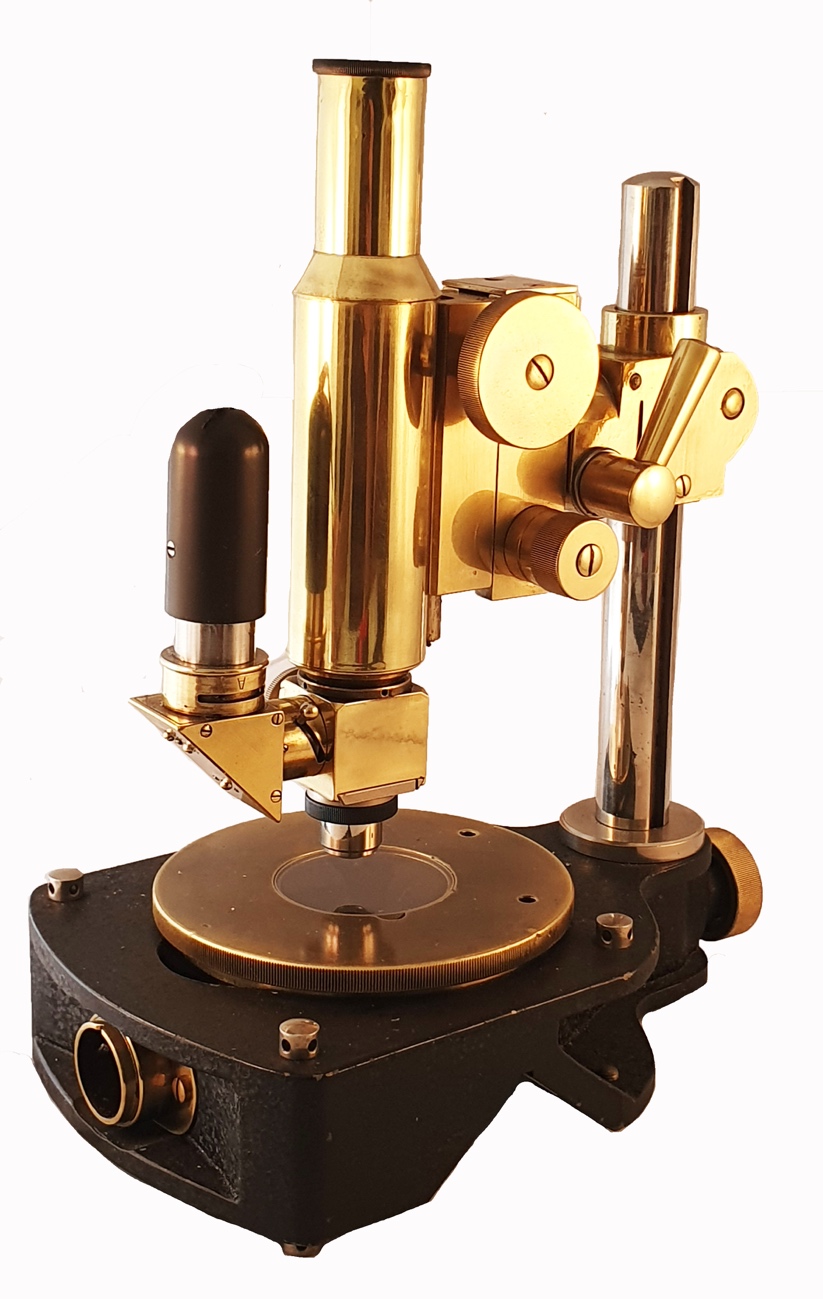 A close-up of a gold microscopeDescription automatically generated