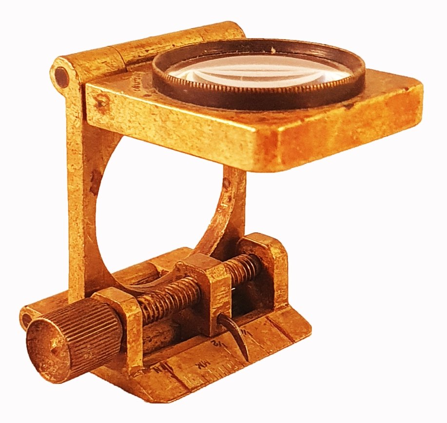 A gold metal object with a magnifying glassDescription automatically ...