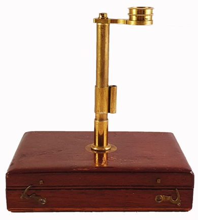 A brass object on a wooden box
Description automatically generated